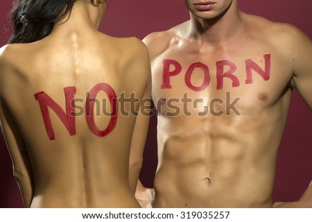 Sexy young undressed couple with no porn message on chest of muscular boy and girl with straight back standing embracing close to each other in studio on purple background, vertical photo