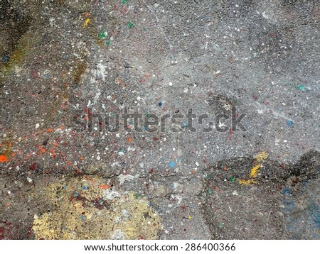 Green, blue, white and orange drops of paint on the asphalt. Perfect for use as a creative artistic background.