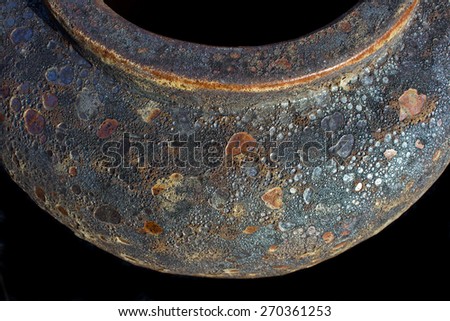 Rustic looking pot shot in an abstract way with dark opening at the top and surrounded by black.