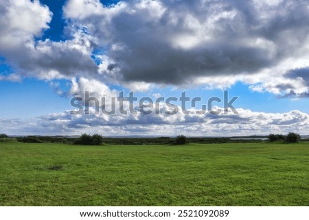 Similar – Foto Bild Ländliches Feld unter bewölktem Himmel mit Sonnenstrahlen