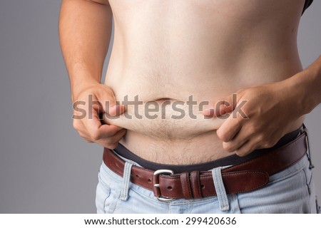 asian man hand holding excessive belly fat