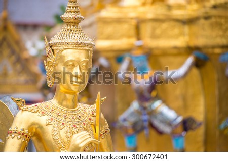 golden statue under golden pagoda in wat pra keaw , Bangkok , Thailand