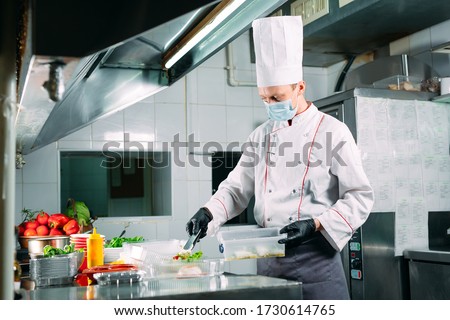 Food delivery in the restaurant. The chef prepares food in the restaurant and packs it in disposable dishes