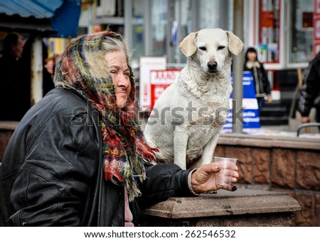 old woman beggar, raising money with a dog on the streets of Kiev