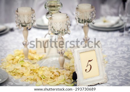 Exquisitely decorated wedding table setting with candles and bouquet of roses