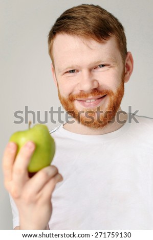 handsome red hair man with red beard in white shirt with green apple