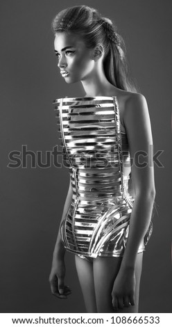 Futuristic pretty woman in dress with creative hairstyle shot in studio