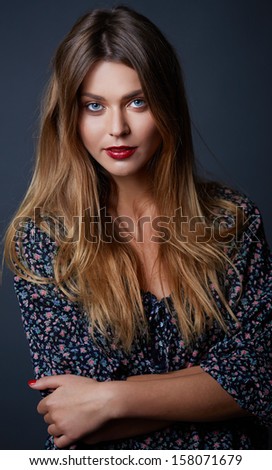 Gorgeous blue eyes woman with red lips make up and  long hair in studio