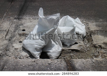 Broken cement road and white plastic bag