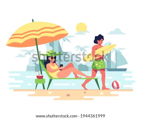 Couples invites each other to a vacation on the beach. The windy waves are perfect for surfing. Good atmosphere, suitable for sunbathing. Young woman use a cell phone in bed under a large umbrella. 