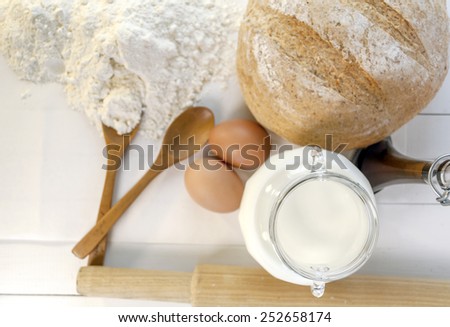 Fresh baked bread and ingredients for cooking, eggs, milk, flour