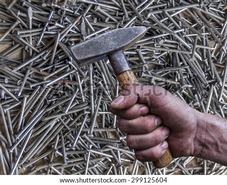 Man\'s hand holding hammer isolated on nail background