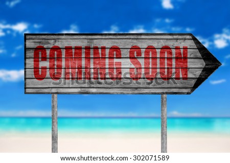 Red Coming Soon wooden sign with on a beach background