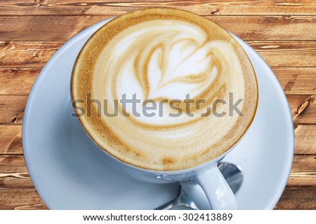 Cup of freshly made espresso in coffee shop on light brown wood