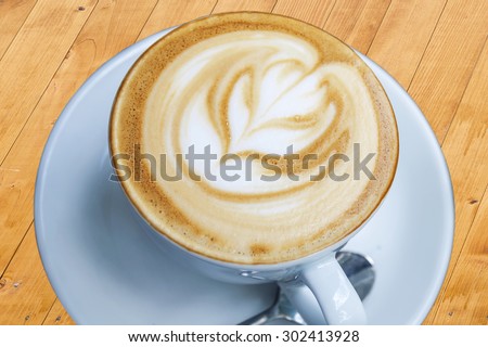 Cup of freshly made espresso in coffee shop on light wood board