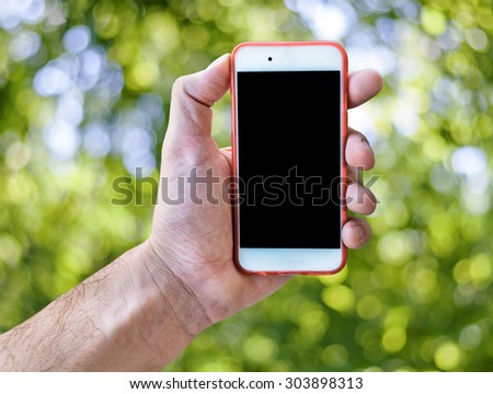 Hand holding touch screen mobile phone isolated green blurry background