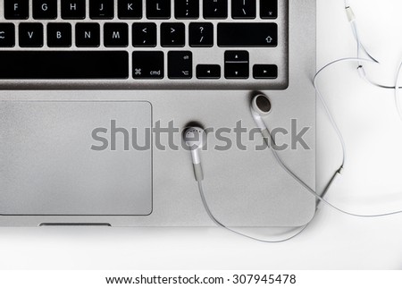 Top view of the keyboard of the laptop on white Desk with headphones