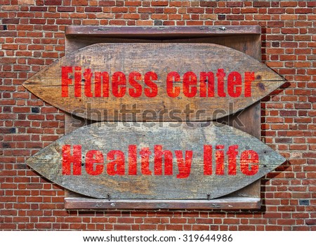Fitness Center and Healthy Life Wooden old sign hanged on brick wall background
