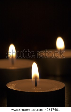 Closeup of burning candles isolated on black background