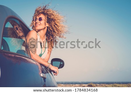 Attractive curly blonde young woman smile and enjoy the wind outside the car - concept of beauty and travel for happy and cheerful caucasian people - alternative lifestyle female feel the freedom joy Foto d'archivio © 