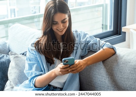 Similar – Image, Stock Photo A smiling girl in a Christmas hat sits on the sofa and communicates via video link with friends and shows them her gift. Girl congratulates friends and family on holidays