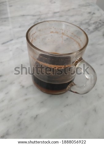 A glass of coffee left over from yesterday afternoon is left on the marble table ストックフォト © 