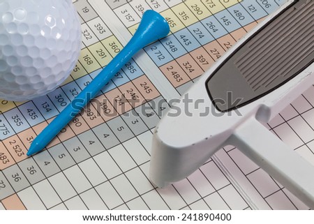 Golf putter and other equipments  lying  on a golf score card