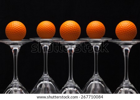 Five glasses of champagne with golf balls