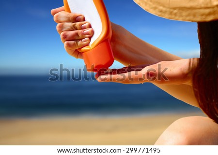 Closeup on hand squeezing sun block creme from a tube