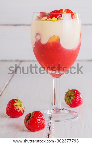 Strawberry tiramisu decorated with pieces of strawberries and pistachios on a white background