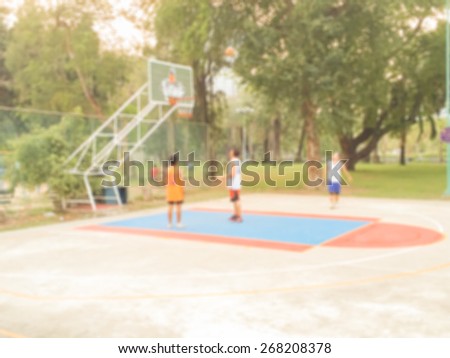 Blur Street Basketball Game with Three Young Player in Evening at Public Park used as Background