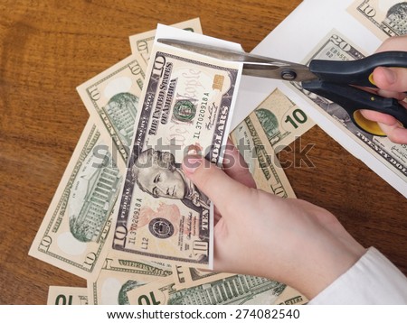 concept of making money, manager scissors cut the printed dollars