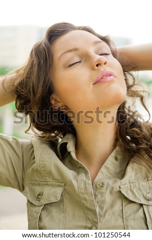 Portrait of a sexy young female with closed eyes smiling and breathing fresh air at morning in a park - Outdoor