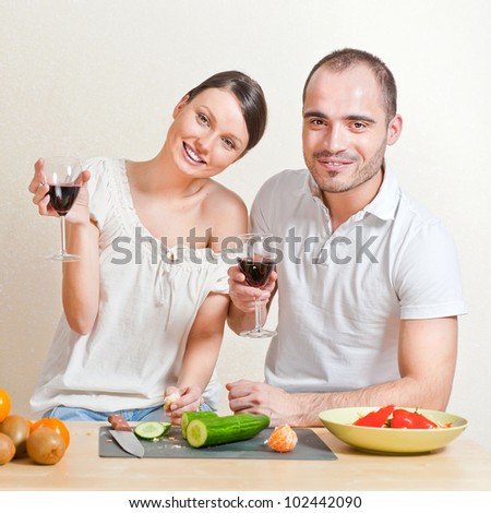 Young love couple cooking and drinking red whine from beautiful glasses. Big copyspace