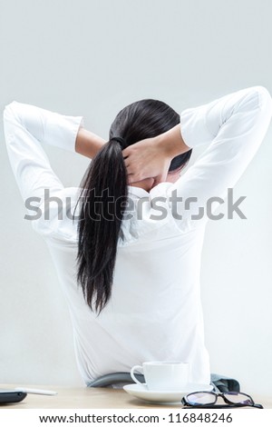 Rear view of young woman suffering from neck ache