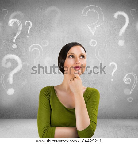 Beautiful woman with questioning expression and question marks above her head
