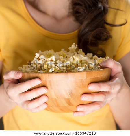 Unrecognizable woman eating popcorn at the cinema