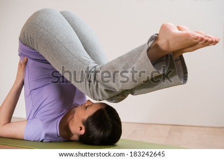 Woman in a traditional stretching yoga pose at home or gym