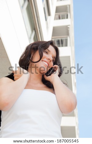 Successful businesswoman or entrepreneur talking on mobile phone while walking outdoor. City business woman working.