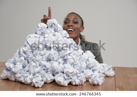African business woman with crumpled pile of papers at workplace at office
