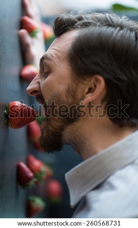 Man eating strawberry from stone wall - surreal photo