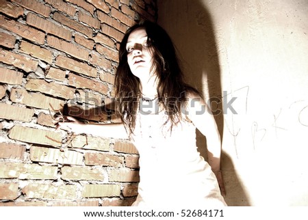 Young beautiful scared addict girl inside abandoned building