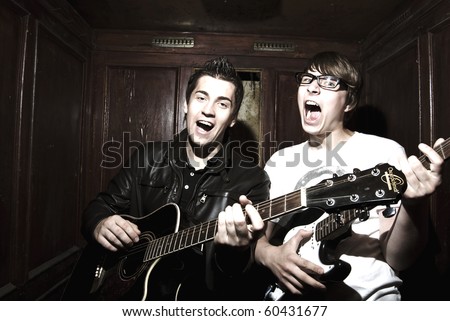 Two young musicians playing music inside vintage elevator