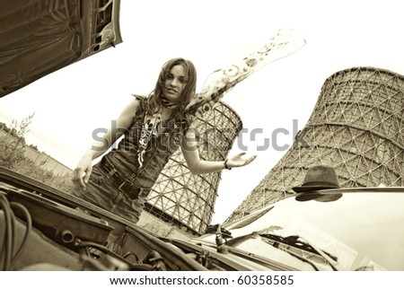 Young woman repairing old broken car. Sepia photo