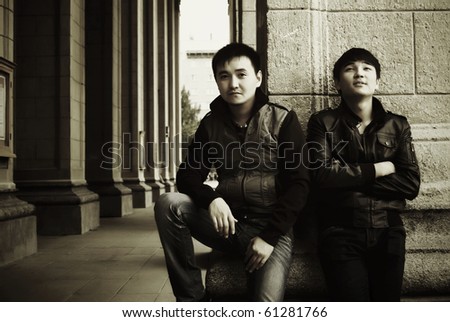 Dramatic portrait of two young asian men against vintage building wall