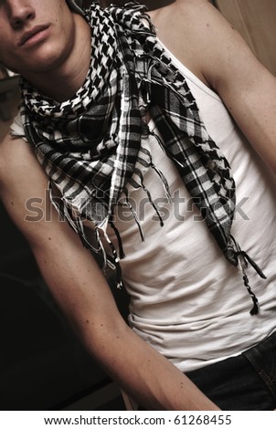 Portrait of young man with perfect body and attractive face wearing modern clothes and scarf posing