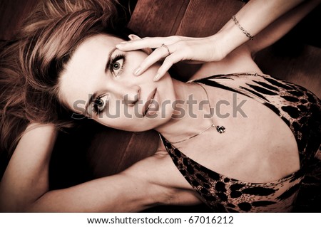 Portrait of pretty young woman laying on stairs at home and posing