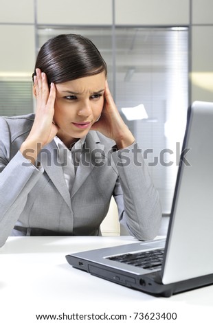 Beautiful business woman thinking about something while working on computer at her office
