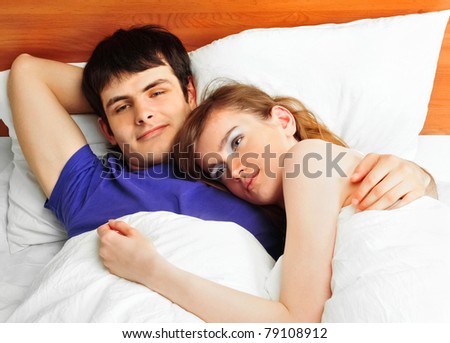 Young man and woman in bed. Couple.