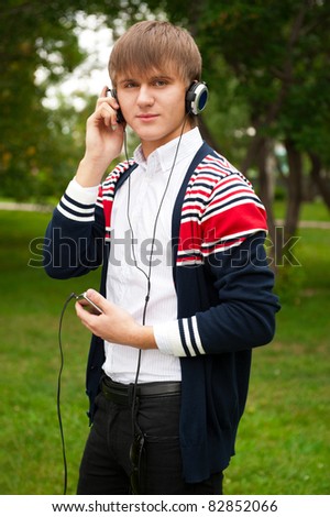 Student listening language course in headphones outside school